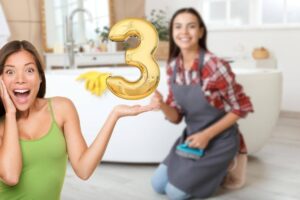 donna sorridente che pulisce bagno e un'altra sorpresa con numero 3 in oro