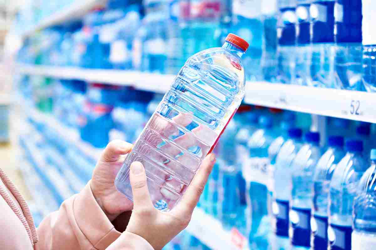 persona con in mano una bottiglietta d'acqua