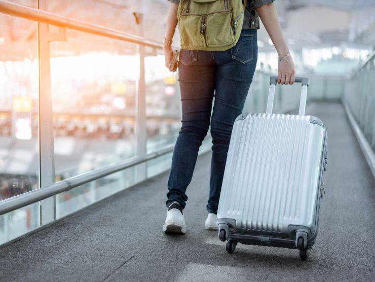 donna in aeroporto con valigia