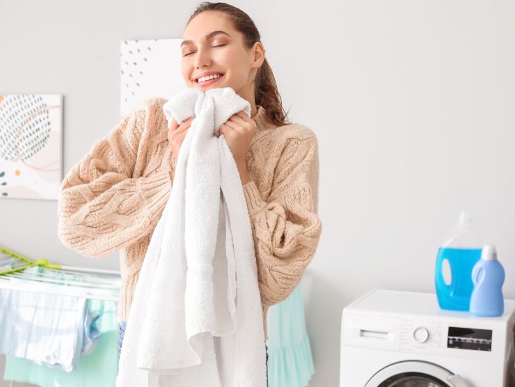 donna sorridente con in mano un asciugamano bianco