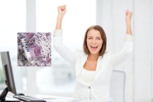 donna seduta davanti al computer che esulta con le braccia in alto e nel riquadro delle banconote di euro