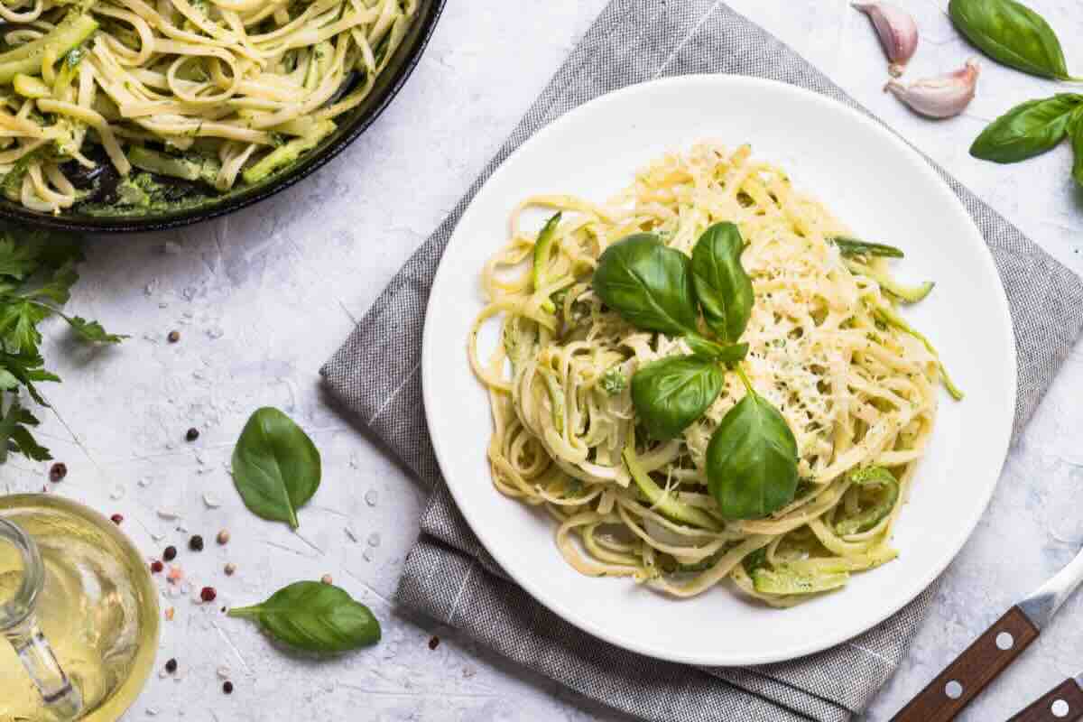 Piatto di spaghetti con formaggio e foglie basilico