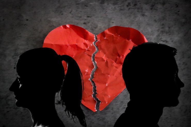 cuore infranto di sfondo e due sagome anonime in primo piano