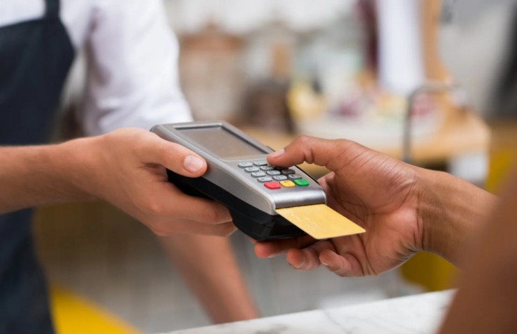 persona che digita il codice sulla tastiera del Pos per pagare con la carta