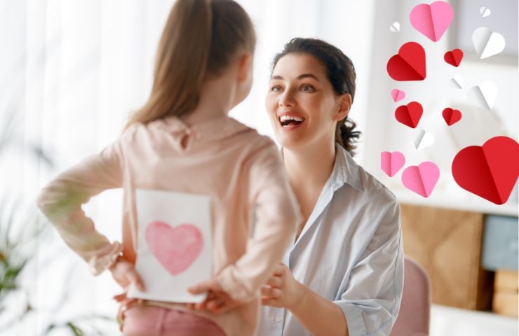 una bambina dà un biglietto alla mamma per la festa della mamma