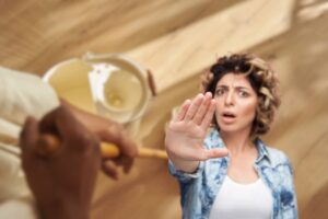 donna che fa stop con le mani e un'altra che lava il pavimento con mocio