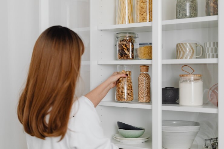 donna che prende pasta dalla dispensa