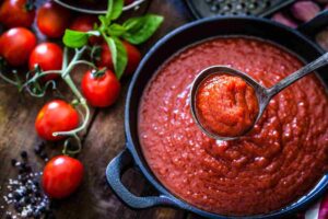 pomodori e pentola con passata di pomodori