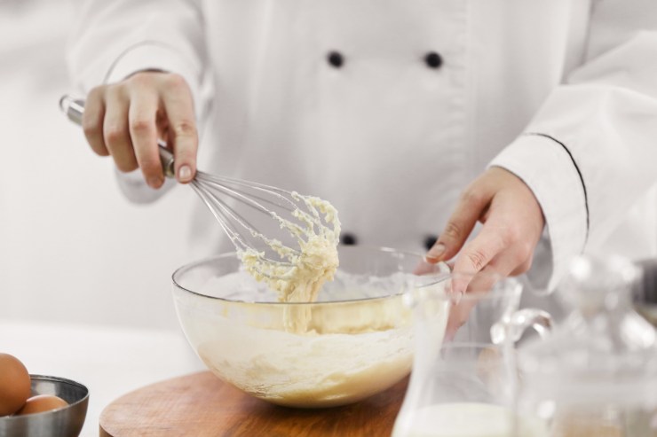 cuoco che prepara l'impasto per un dolce