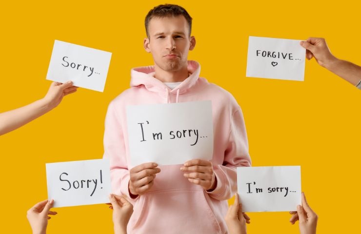 un ragazzo che ha un foglio in mano con scritto sorry