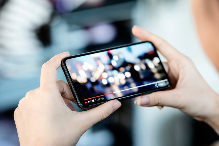 persona che vede un video sul telefono 