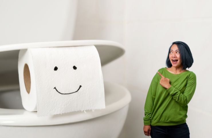 wc con un rotolo di carta igienica ed una ragazza stupita