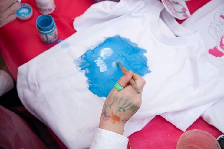Mano dipinge di azzurro t-shirt bianca