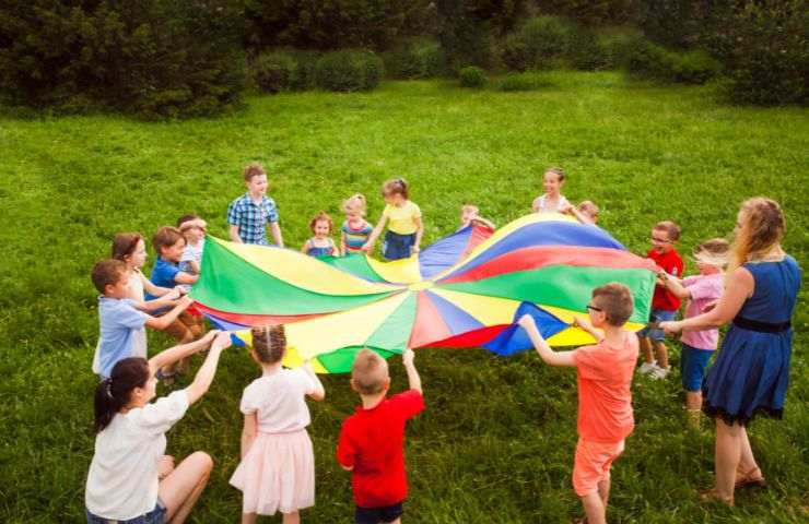 ragazzi che giocano con un telo colorato